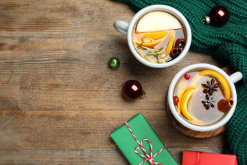 Aromatic mulled wine on wooden table, flat lay. Space for text