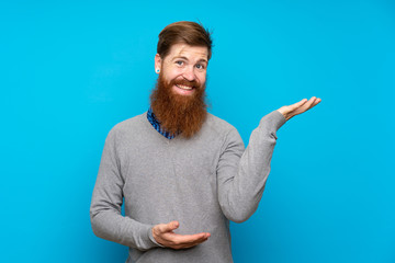 Redhead man with long beard over isolated blue background extending hands to the side for inviting to come