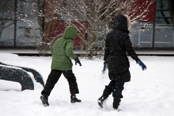 Zwei Passanten laufen im Schnee