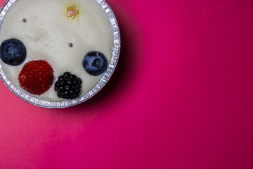 Cheesecake with berries on a pink background