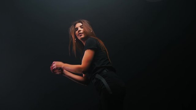 Young woman with long hair dancing in the dark