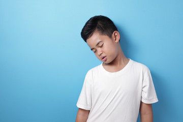 Tired Asian boy slept against blue background