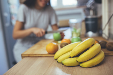 woman preparing fruit smoothie in her kitchen