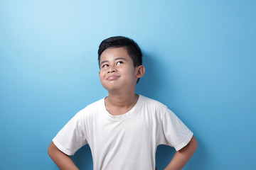 Asian boy looking up, thinking something good and smile