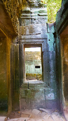 Fototapeta na wymiar Stone rock ruin window at Ta Prohm Temple in Angkor wat complex, Siem Reap Cambodia.
