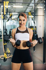 Fototapeta premium Young sports girl are engaged in fitness, lifestyle, sports and healthy eating, in the gym girls do exercises 