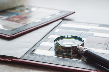 Still life with stamps in an album and magnifying glass. Ukrainian stamps