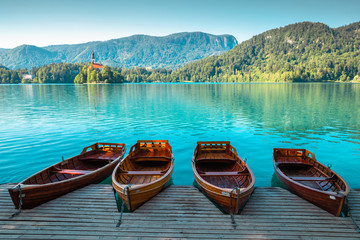 Fototapety  Jezioro Bled, drewniane łodzie i kościół pielgrzymkowy Wniebowzięcia Marii w Słowenii