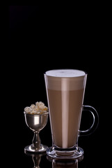 Coffee latte in glass cup with popcorn in separate cup