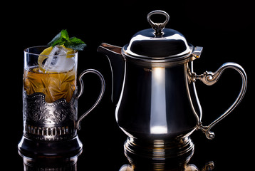 Tea with ice and mint in kettle and glass