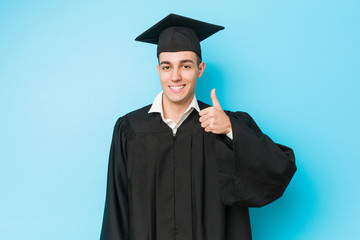 Young caucasian graduated man smiling and raising thumb up