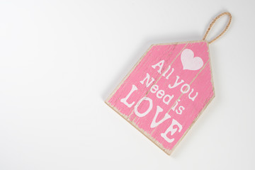 Wooden plank pink with an inscription on a white background for Valentine's Day, wedding, birthday and other holidays, view from the top.