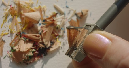 Girl sharpening colored pencils with sharpener