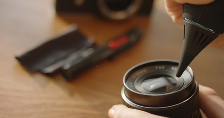 Woman cleaning manual lenses with an air blower