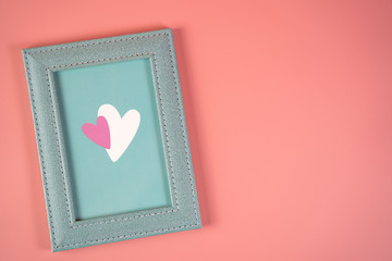 Blue frame with hearts on a pink background, concept for Valentine's Day, wedding, birthday and other holidays, view from the top.