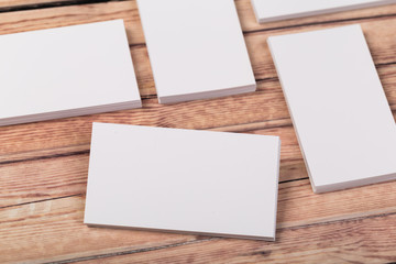 Photo of empty business cards on a light natural wooden background .. Template for identifier.