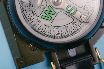 metal navigation travel compass on a blue background. search for a way. point of view