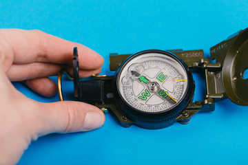 metal navigation travel compass on a blue background. search for a way. point of view