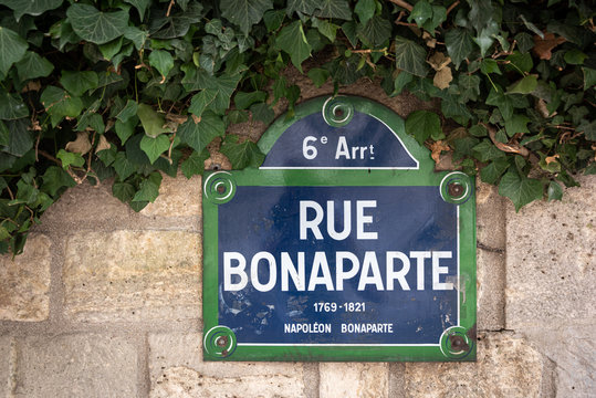 Paris Blue and Green enameled street sign Rue Bonaparte, 6th Arrondissement against a brick and Ivy covered background