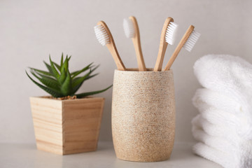 Organic bamboo toothbrushes with white towels in the bathroom