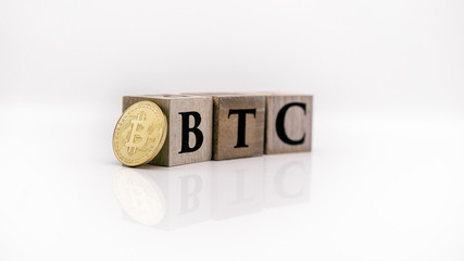 BTC Bitcoin Buchstaben mit goldener Bitcoin Münze auf Augenhöhe