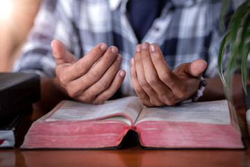 Obraz na płótnie Canvas Hands praying on Bible, Christian concept.