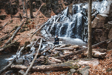 Man practicing kendo with bamboo sword on waterfall background. Place for text or advertising