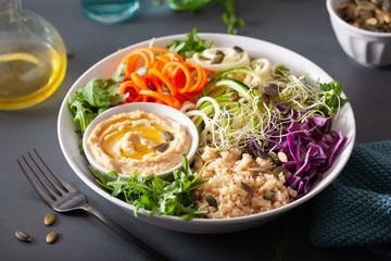 veggie couscous lunch bowl with spiralazed carrots and zucchini, hummus and red cabbage