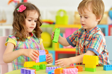 Naklejka premium Portrait of bother and sister playing with cubes