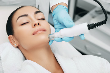 woman receiving no-needle high frequency mesotherapy at beauty salon. non-invasive procedure for skin rejuvenation - obrazy, fototapety, plakaty