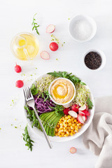 vegan avocado sweet corn lunch bowl with hummus, red cabbage, radish and sprouts
