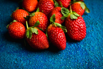 Ripe and juicy strawberries on the dark rustic background. Selective focus. Shallow depth of field.