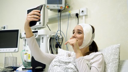 Beautiful girl vlogger recording vlog at modern hospital. Social media influencer sharing beauty video. 4K