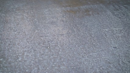 Worker puts primer with roller on concrete floor. Apartment under construction. The worker primers the concrete floor for further installation.