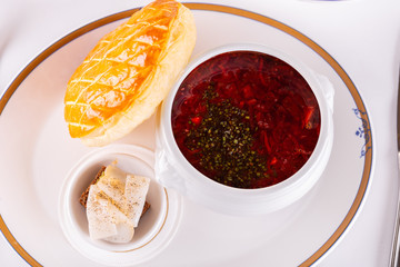 Borsch in a plate, served with a bun of white and lard with black bread