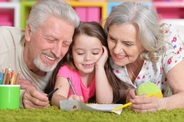 Close up portrait of grandparents playing with grandaughter