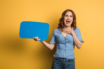 Naklejka premium excited girl laughing while holding speech bubble on yellow background