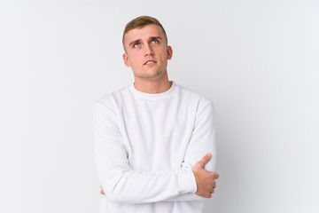 Young caucasian man on white background tired of a repetitive task.