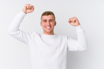 Young caucasian man on white background celebrating a special day, jumps and raise arms with energy.