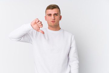 Young caucasian man on white background showing a dislike gesture, thumbs down. Disagreement concept.