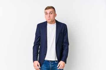 Fototapeta premium Young business caucasian man shrugs shoulders and open eyes confused.