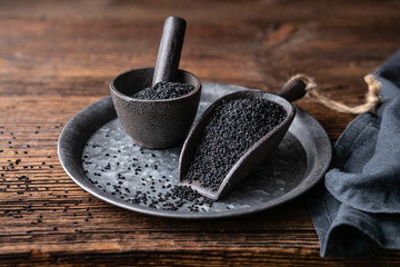 Nigella sativa seeds also known as black cumin, kalo jeera, kalonji and black caraway in iron scoop and mortar