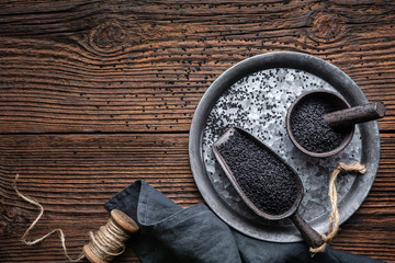 Nigella sativa seeds also known as black cumin, kalo jeera, kalonji and black caraway in iron scoop and mortar with copy space