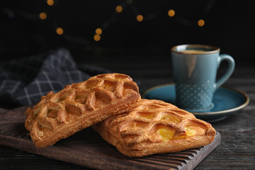 Delicious pastries and coffee on black wooden table