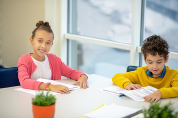 Boy and a girl preparing their homework together