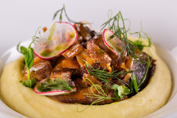 Fried fox mushrooms with greens and radish, served with puree potatoes