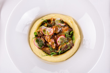 Puree potatoes with fried mushrooms and fried meat with greens