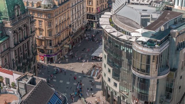 People walking in the Old city center of Vienna in Stephansplatz aerial timelapse. Shops and restaurants around, crowded place. View from St. Stephan cathedral viewpoint