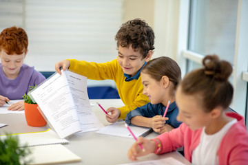 Generous boy sharing his test answers with the classmate