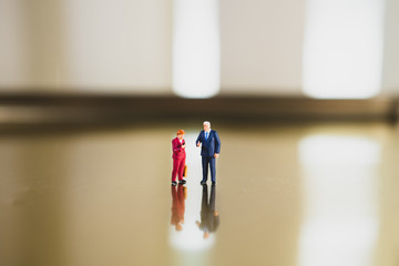 Miniature man and woman standing together using as business teamwork concept